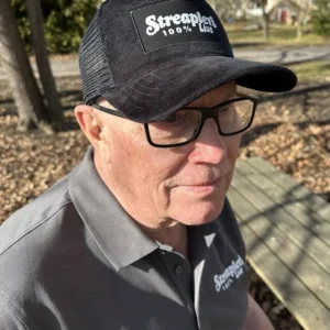 Person som bär vit truckerkeps med Streaplers logga framtill.